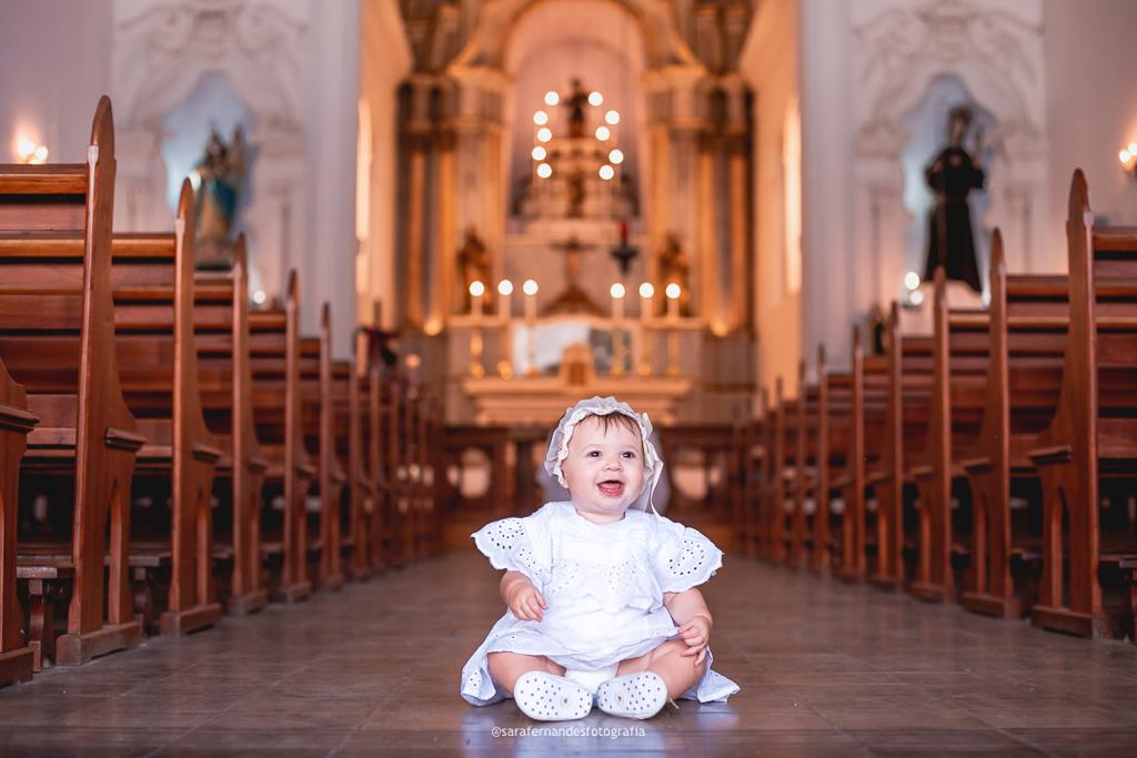 Criança sorrindo em frente ao altar da Igreja de São Gonçalo.