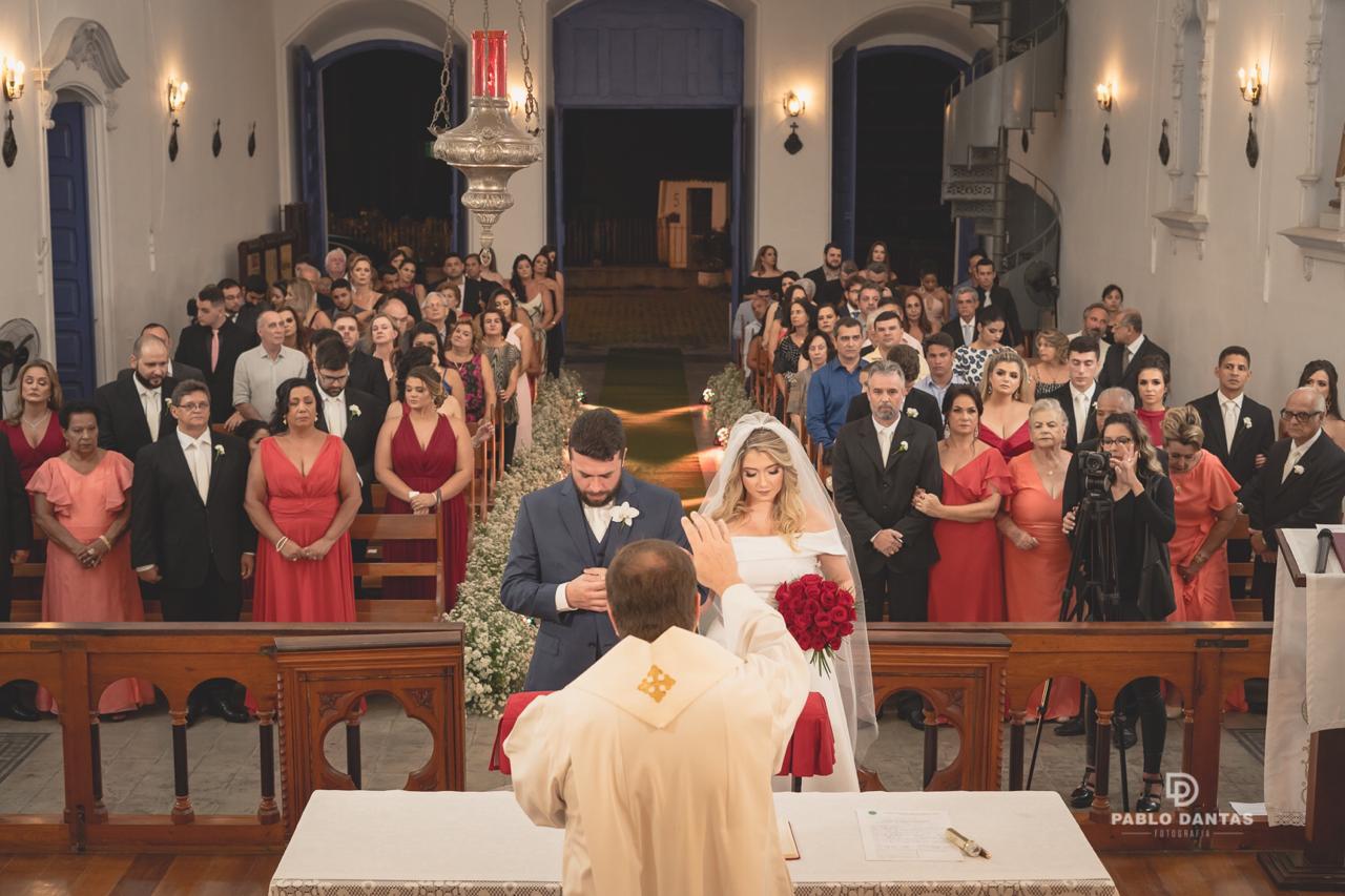 Visão panorâmica do interior da Igreja de São Gonçalo durante cerimônia de casamento com convidados nos bancos e noivos no altar.